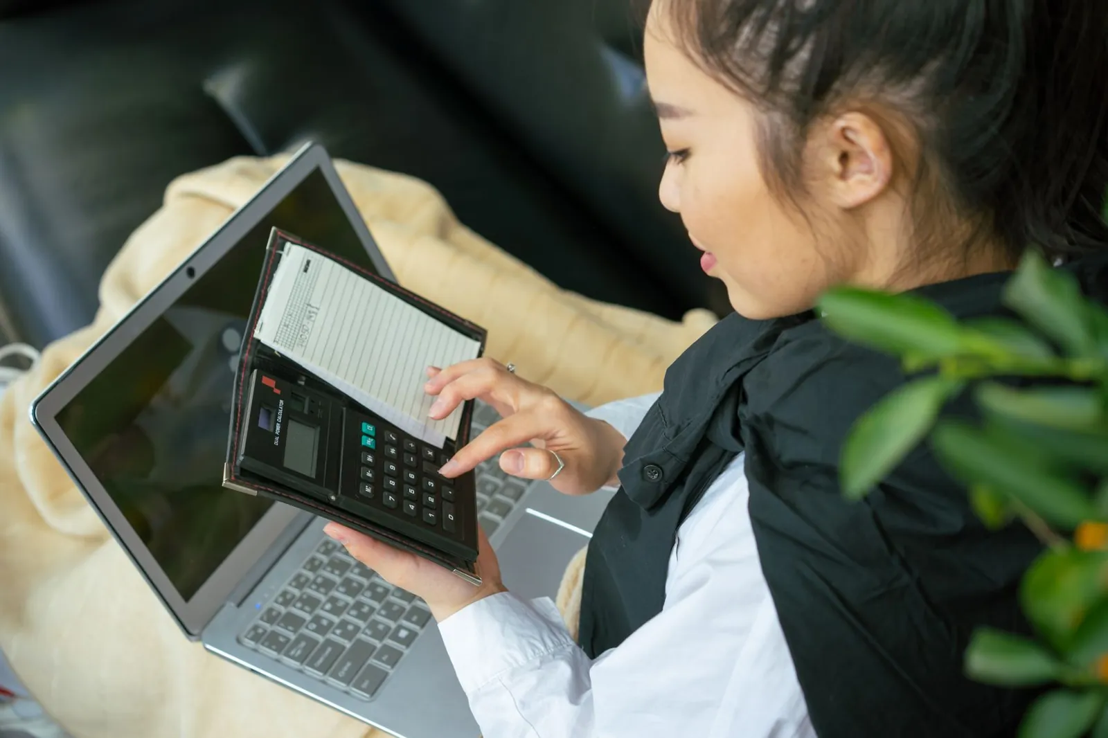 A prospective student working out baking diploma course fees on a laptop with a calculator
