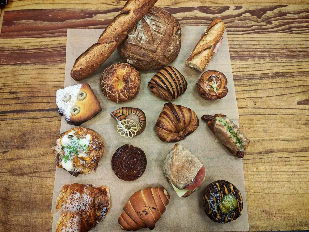 Flat-lay of Chef Terry's artisan breads and viennoiserie, including sourdough, baguette and croissants